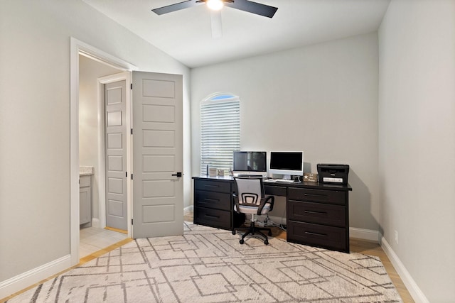 home office with ceiling fan, vaulted ceiling, and baseboards