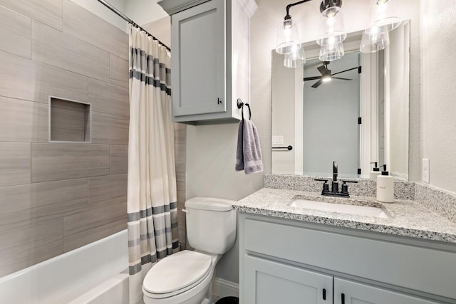 bathroom featuring a textured wall, toilet, vanity, a ceiling fan, and shower / bath combo with shower curtain