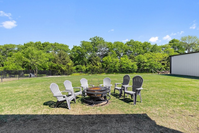 view of yard with a fire pit and fence