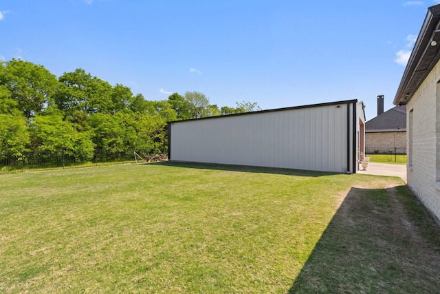 view of yard with fence, an outbuilding, and an outdoor structure