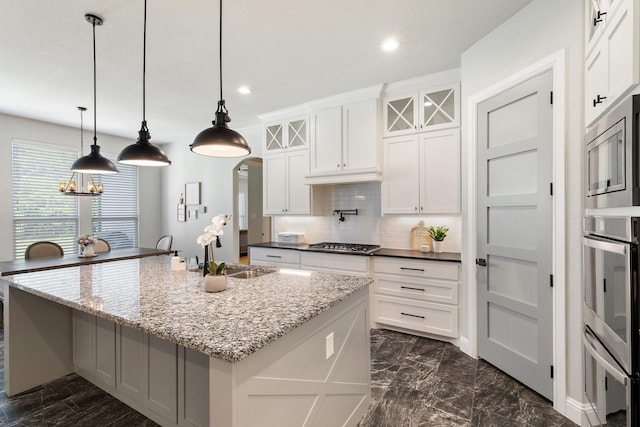 kitchen featuring tasteful backsplash, a sink, stainless steel appliances, white cabinetry, and recessed lighting