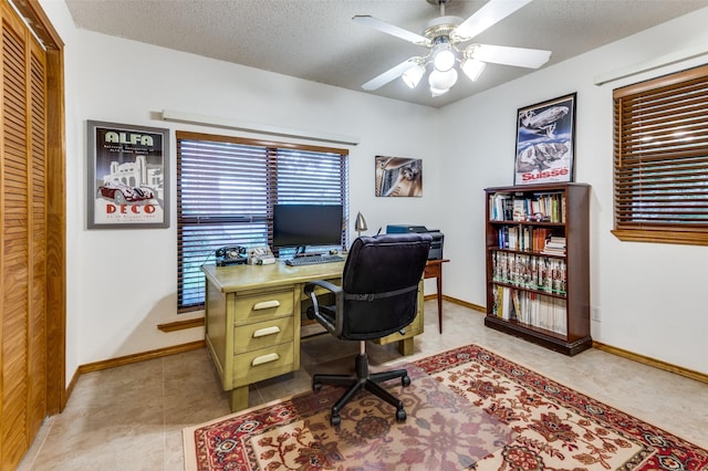 home office featuring a textured ceiling, ceiling fan, and baseboards