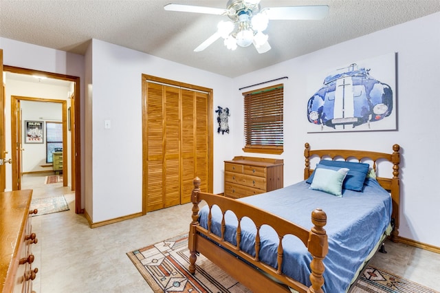 bedroom featuring baseboards, a ceiling fan, a textured ceiling, and a closet