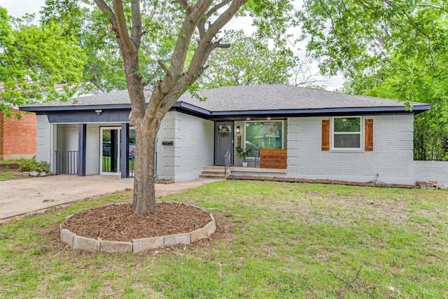 single story home featuring concrete driveway, brick siding, a front lawn, and a carport
