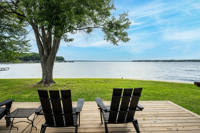 wooden terrace featuring a water view and a lawn