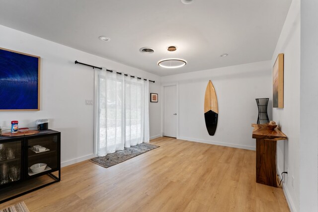 foyer entrance featuring visible vents, baseboards, and light wood-type flooring