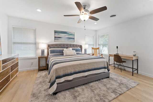 bedroom featuring baseboards, visible vents, ceiling fan, and light wood-style floors