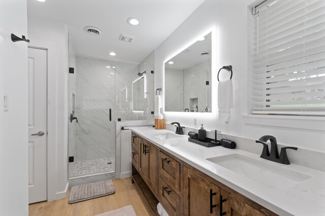 bathroom featuring visible vents, a marble finish shower, and a sink