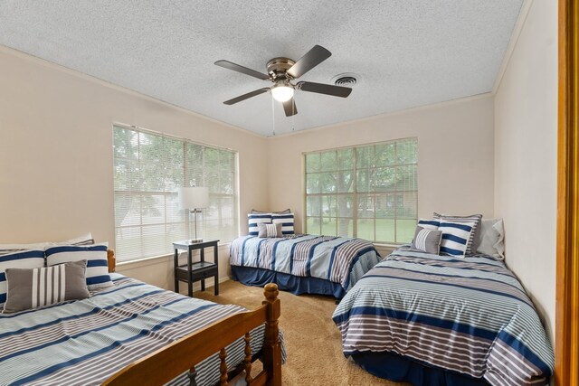 carpeted bedroom with visible vents, a ceiling fan, and a textured ceiling