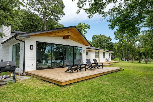 back of property featuring a lawn, a wooden deck, and a chimney