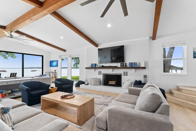living area featuring recessed lighting, vaulted ceiling with beams, wood finished floors, a water view, and visible vents