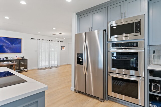 kitchen with recessed lighting, light wood-style floors, appliances with stainless steel finishes, and light countertops