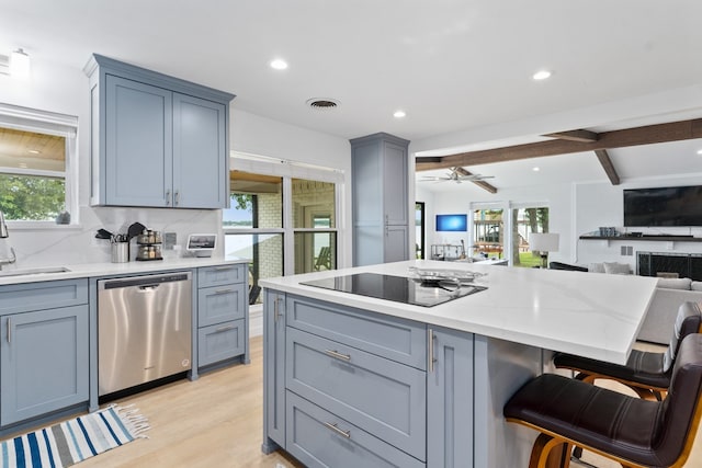 kitchen with gray cabinetry, black electric cooktop, stainless steel dishwasher, and open floor plan