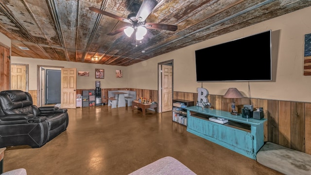 2380 County Road 422, Huckabay, TX 76401 - living room with finished concrete flooring, wooden ceiling, a wainscoted wall, and a ceiling fan