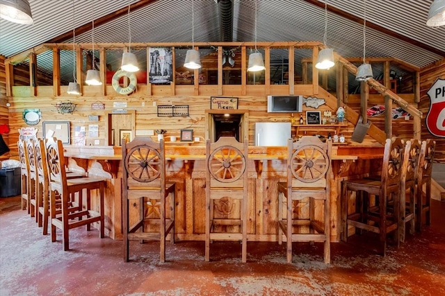 interior space featuring lofted ceiling and wooden walls