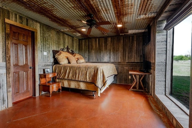 bedroom with concrete flooring, wood walls, and access to exterior