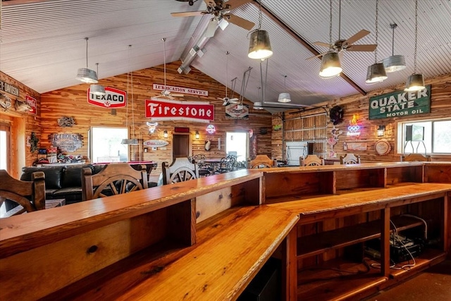 interior space featuring beamed ceiling, wooden walls, and ceiling fan