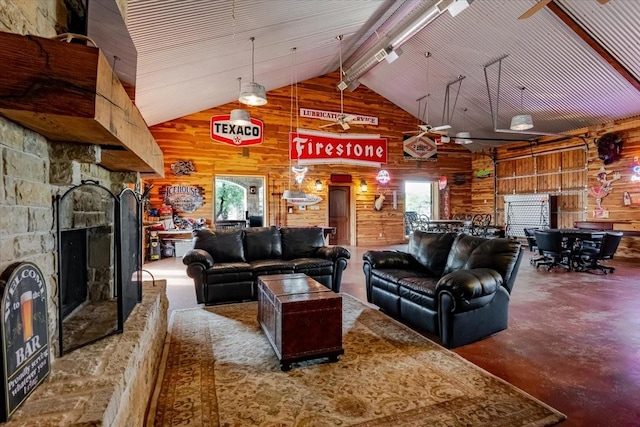 living room with wooden walls, beam ceiling, finished concrete flooring, and high vaulted ceiling