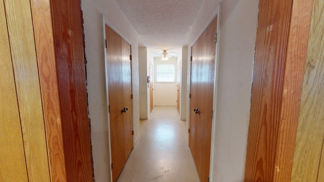 hall with a textured ceiling