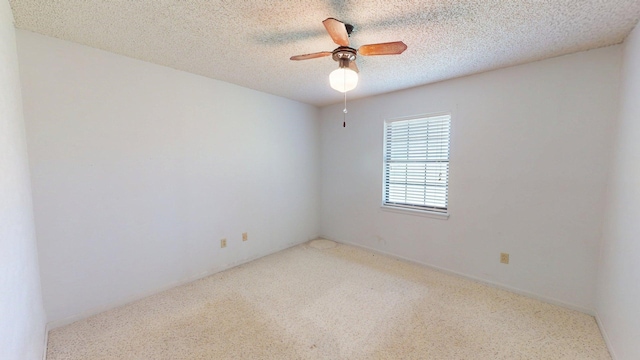 carpeted empty room with ceiling fan and a textured ceiling