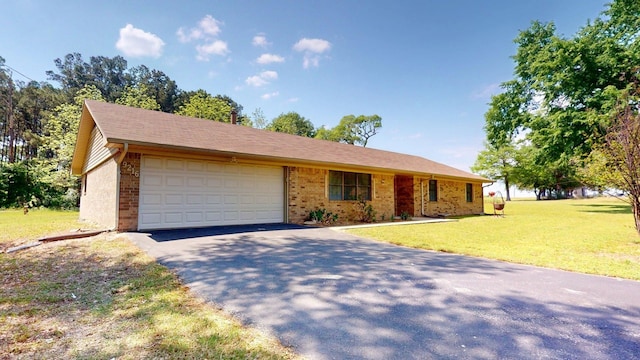 ranch-style house featuring brick siding, an attached garage, a front lawn, and aphalt driveway
