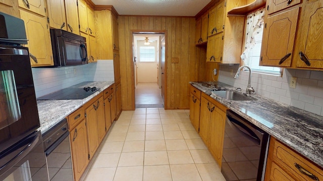kitchen featuring a sink, tasteful backsplash, black appliances, brown cabinetry, and ornamental molding