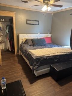 1081 Hoben Rd, Nocona, TX 76255 - bedroom featuring a spacious closet, wood finished floors, a ceiling fan, a closet, and crown molding