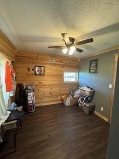 1081 Hoben Rd, Nocona, TX 76255 - miscellaneous room featuring wood walls, baseboards, ceiling fan, and dark wood finished floors