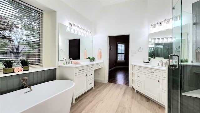 4406 Bay Valley Dr, Garland, TX 75043 - full bathroom featuring a shower stall, vaulted ceiling, wood finished floors, a sink, and a soaking tub