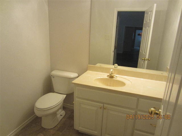 bathroom with baseboards, vanity, tile patterned floors, and toilet