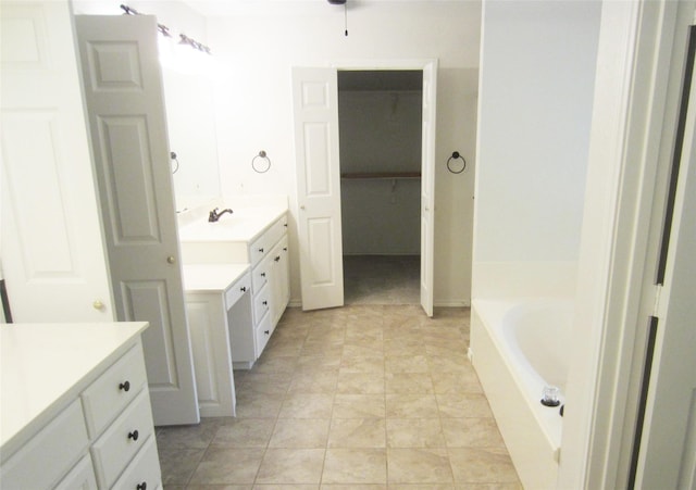 full bathroom featuring a bath, vanity, and tile patterned floors