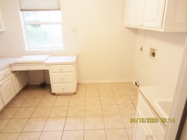 laundry area featuring cabinet space, hookup for a washing machine, baseboards, and light tile patterned flooring
