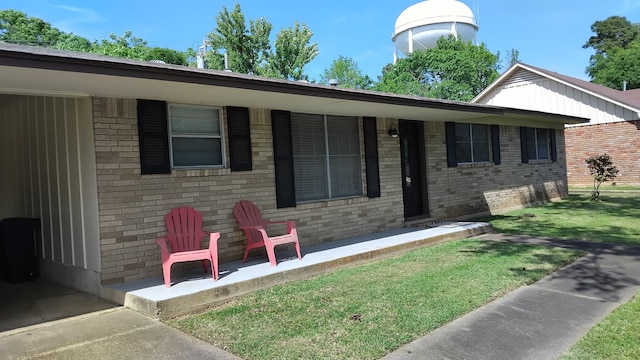 single story home featuring brick siding and a front yard