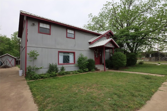 view of front of house featuring an outdoor structure, a shed, a front lawn, and metal roof