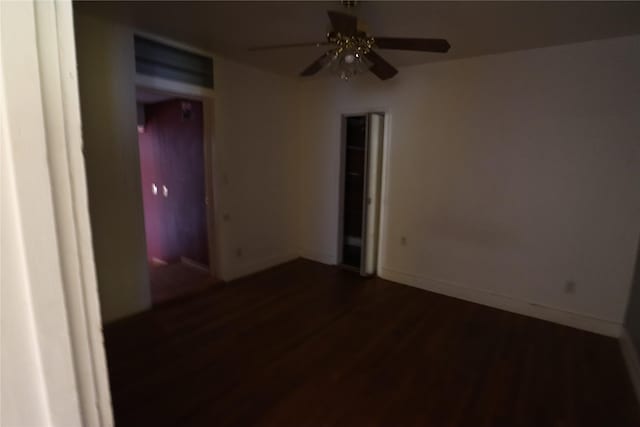 spare room featuring wood finished floors, baseboards, and ceiling fan