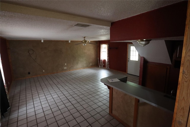 foyer entrance with light tile patterned flooring, a textured ceiling, a ceiling fan, and visible vents