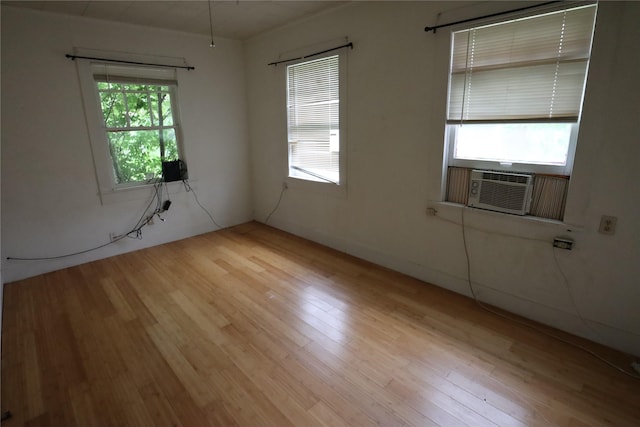 spare room featuring wood finished floors and cooling unit