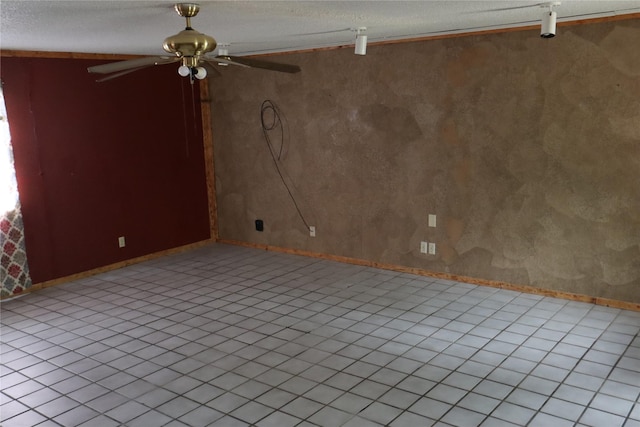 spare room featuring a ceiling fan and baseboards
