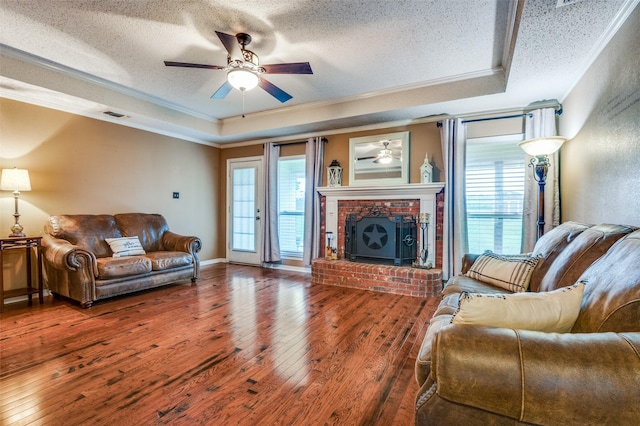 3451 Sudith Ln, Midlothian, TX 76065 - living area featuring a raised ceiling, crown molding, a ceiling fan, hardwood / wood-style flooring, and a textured ceiling
