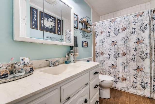 full bath featuring vanity, toilet, a textured ceiling, wood finished floors, and a shower with curtain