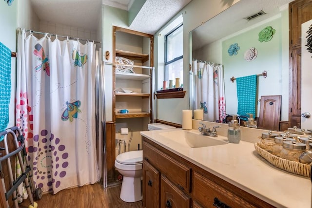 bathroom featuring vanity, toilet, a shower with shower curtain, wood finished floors, and visible vents