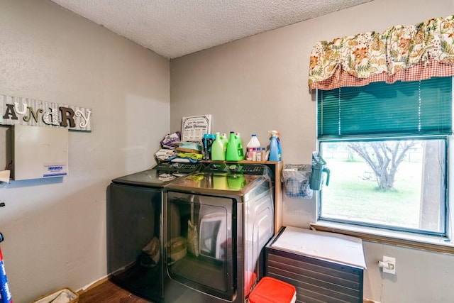 washroom with laundry area, a textured ceiling, baseboards, wood finished floors, and washing machine and dryer