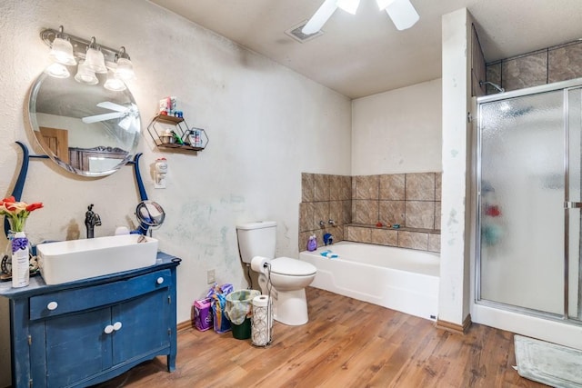 full bathroom with a ceiling fan, wood finished floors, toilet, and a shower stall