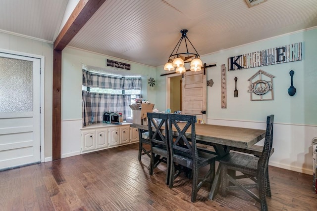 dining space with dark wood-style flooring, an inviting chandelier, and ornamental molding