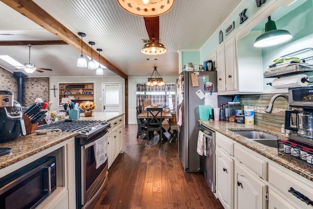 4158 Fm 6, Caddo Mills, TX 75135 - kitchen with stainless steel appliances, a wood stove, a sink, white cabinets, and beam ceiling
