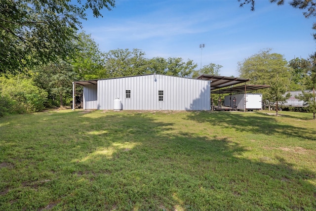 view of yard featuring a pole building, an outbuilding, and a carport