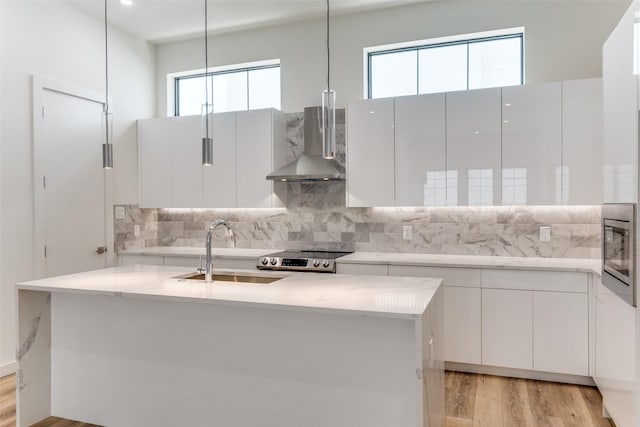 1775 Novela Way, Dallas, TX 75215 - kitchen featuring wall chimney range hood, a sink, stainless steel appliances, light wood-style flooring, and backsplash