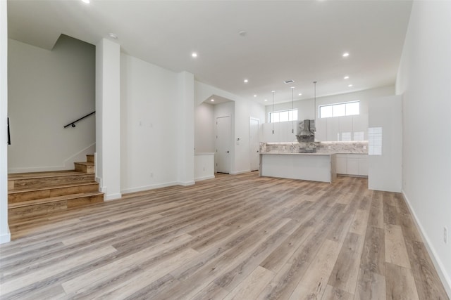 1775 Novela Way, Dallas, TX 75215 - unfurnished living room with light wood-style floors, stairs, recessed lighting, and baseboards