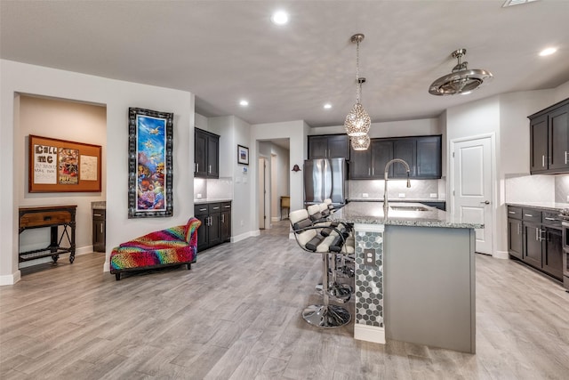 736 Wilmott Ter, Fort Worth, TX 76247 - kitchen with a sink, freestanding refrigerator, tasteful backsplash, recessed lighting, and light stone counters