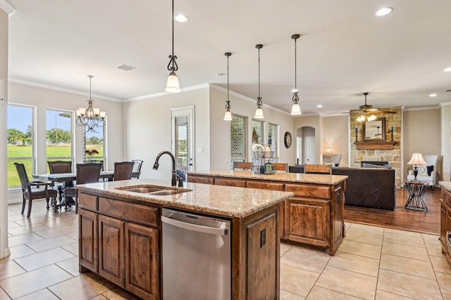 kitchen featuring a sink, a center island with sink, dishwasher, a stone fireplace, and light tile patterned floors